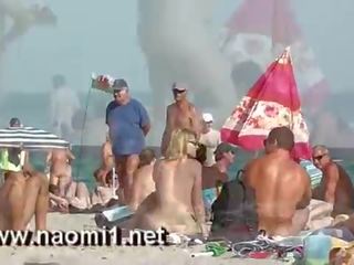 Naomi1 branlette une jeune copain sur une publique plage